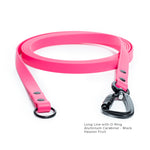 A passion fruit biothane lone line with an O-ring and matte black carabiner coiled on a white background.