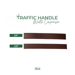 two rectangular brown leather handles, one 3/4" wide and the other 5/8" wide, with a green traffic hand label indicating the width comparison.