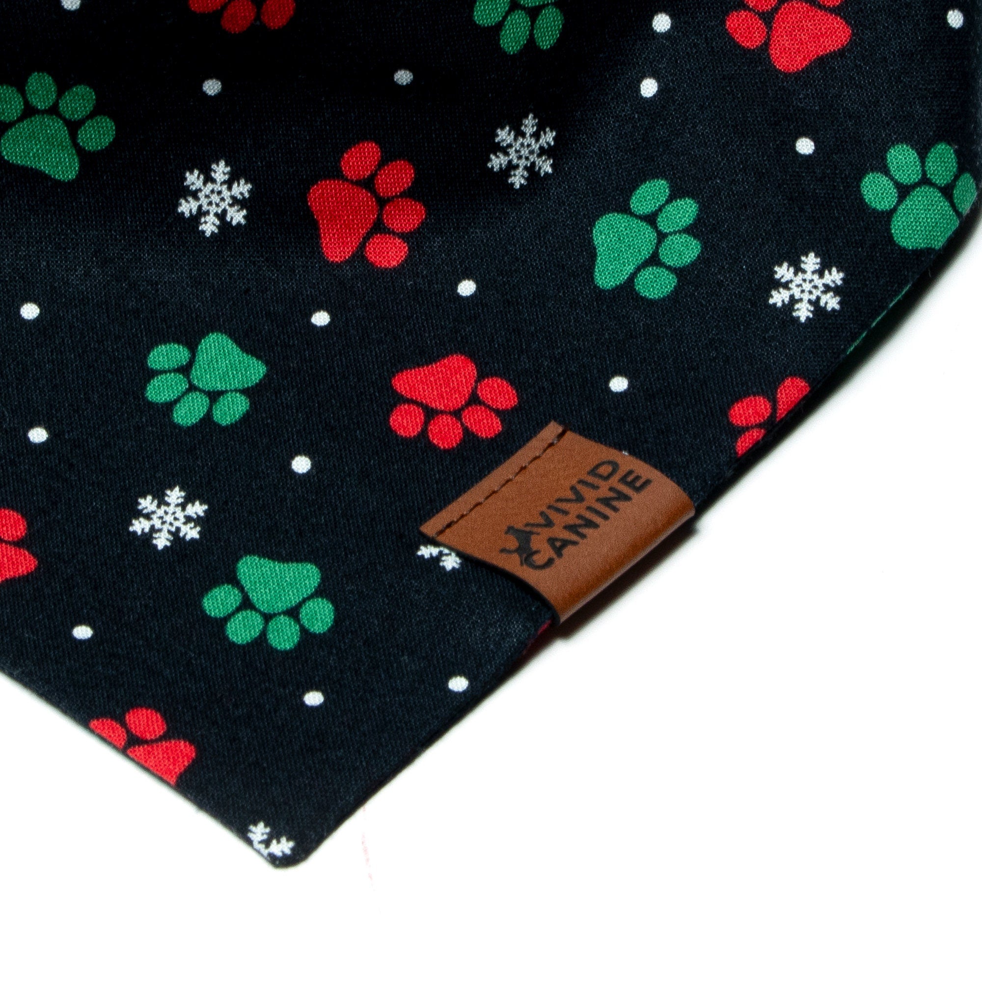 Christmas dog bandana with red and green paw prints and a vivid canine label